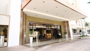 En hotelindgang med et overdækket område, glasdøre og et skilt med teksten 'Boulevard Suite Hotel'.