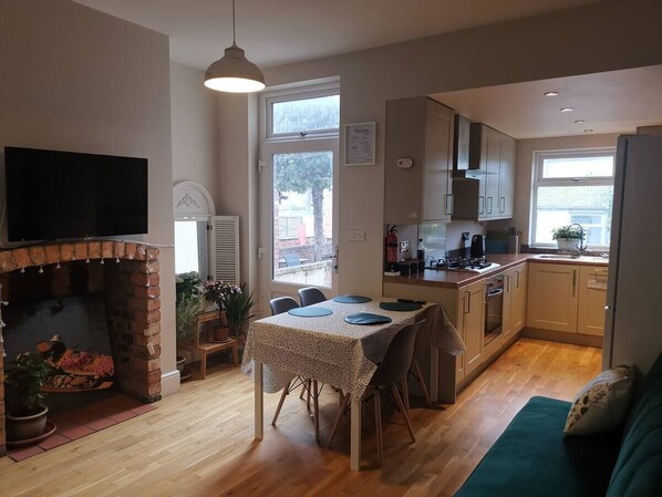 Una cocina acogedora con comedor, chimenea y vistas al exterior.