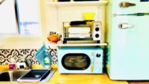 Una cocina con microondas, tostadora y lavaplatos.