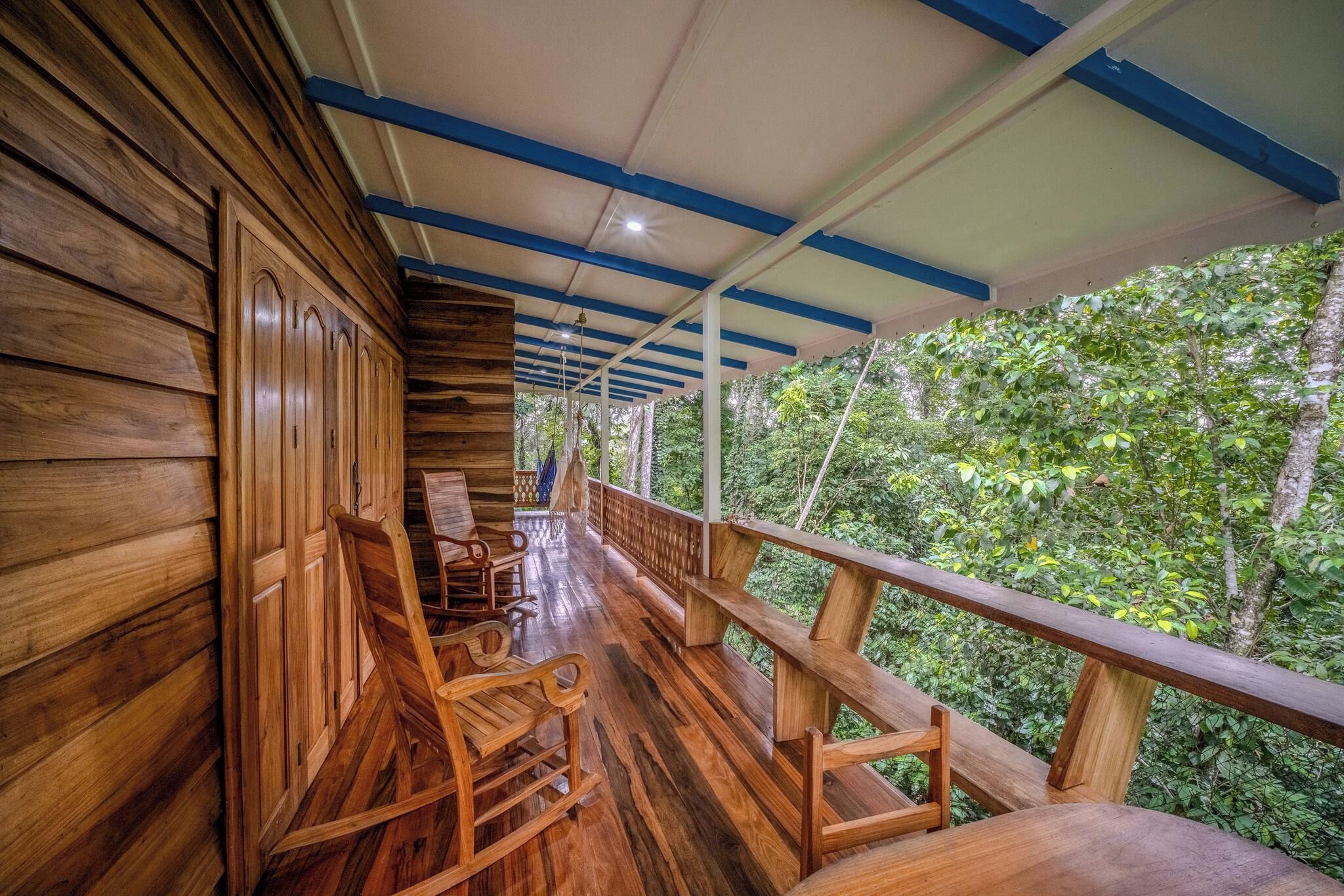 A wooden cabin with a balcony overlooking a forest.