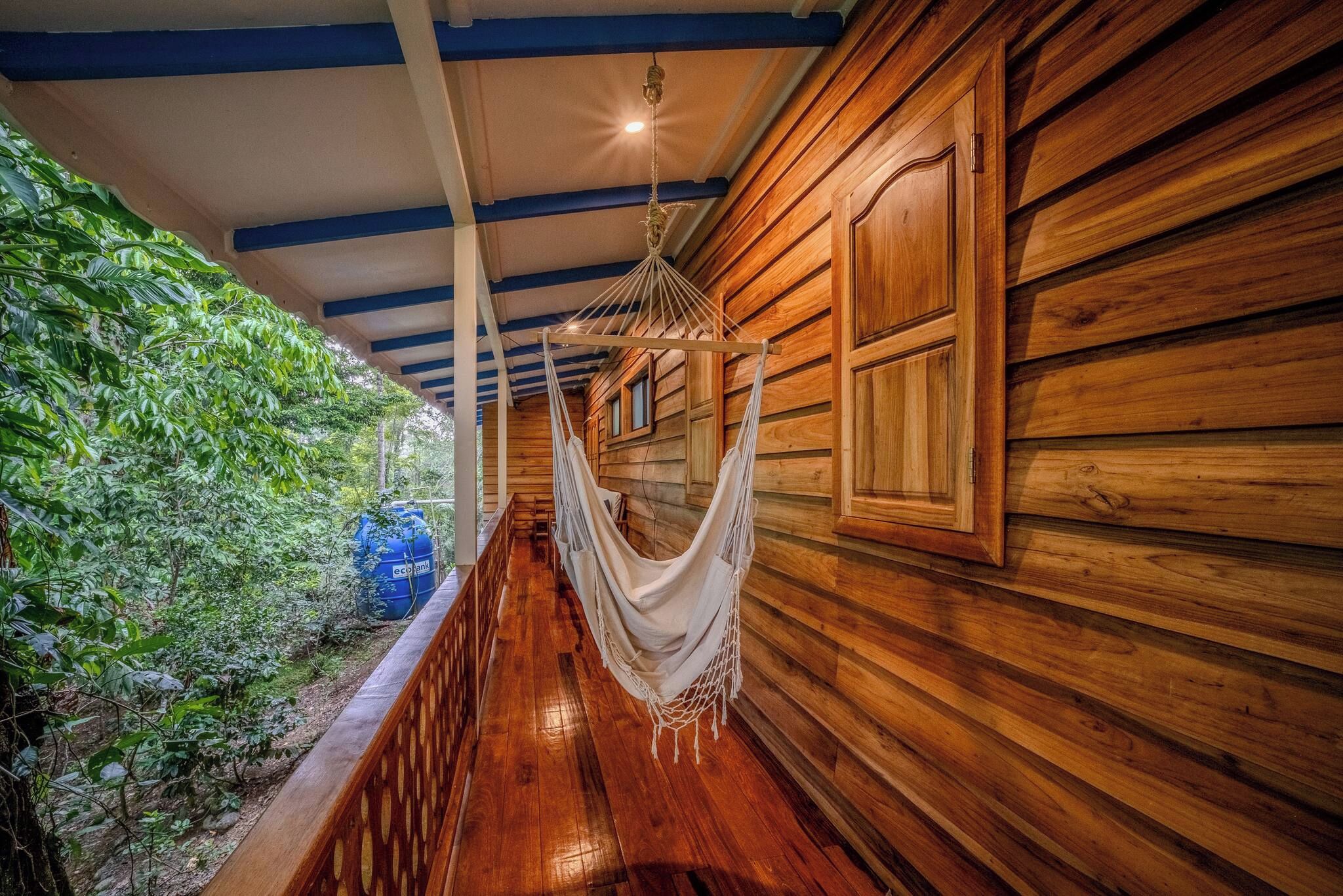 A wooden hallway with a hammock suspended from the ceiling.