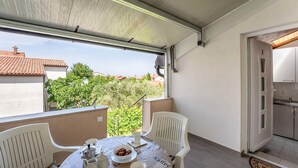 Ein Balkon mit einem Tisch für zwei Personen, einer Kaffeemaschine und einer Schüssel Kekse.