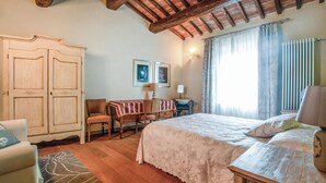 A bedroom with a large bed, a wooden wardrobe, a desk with a chair, and a window with curtains. - Pet friendly home in Mazzolla (Mazzolla)