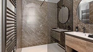 A modern bathroom with a shower, a vanity with a mirror, and a towel rack. - 3 bedroom beautiful home in Den Oever (Den Oever)