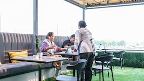 Een terras met een zachte bank, een tafel en stoelen.