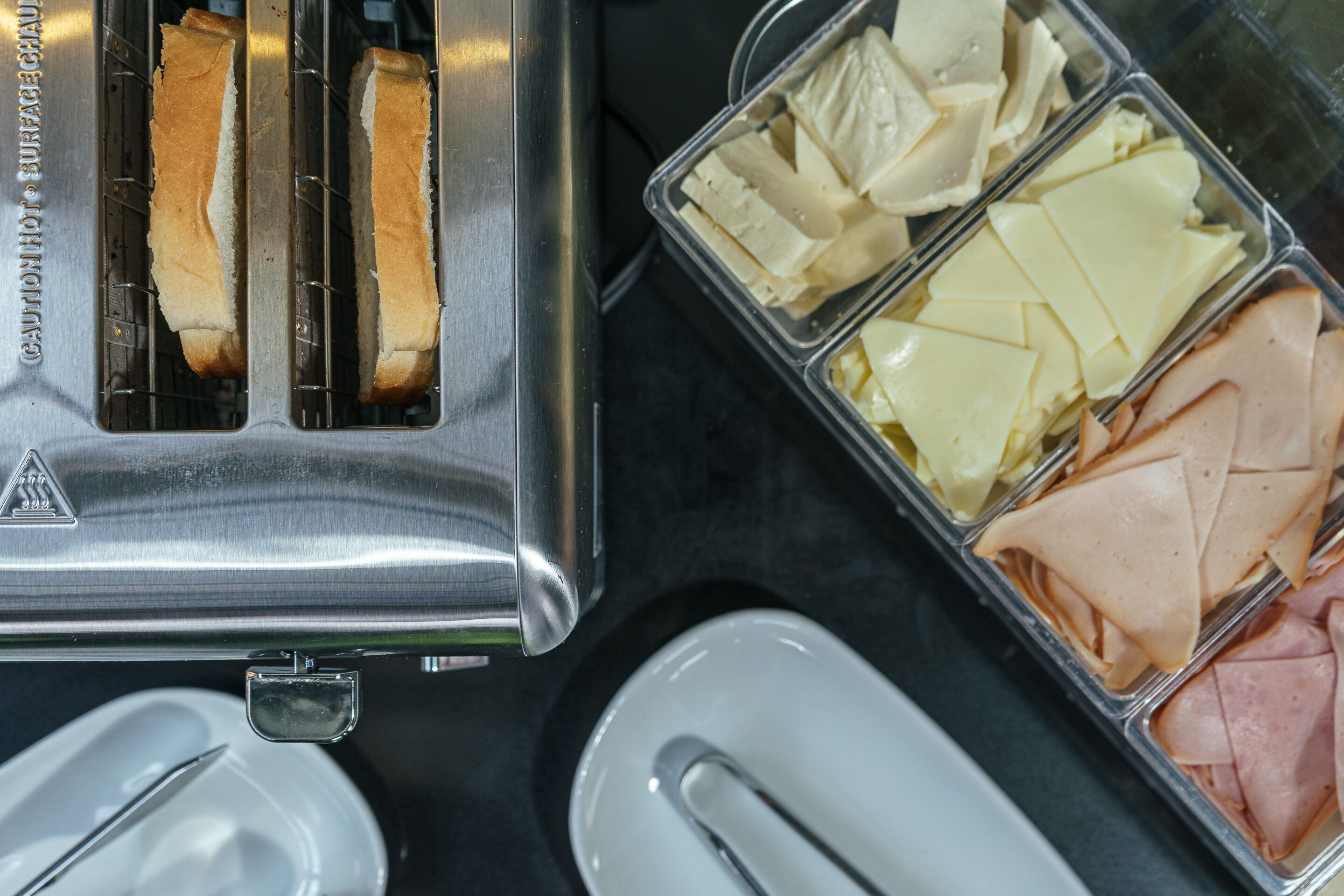 Un tostador de acero inoxidable con recipientes para pan y queso.