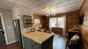 Una cocina con armarios de madera, una isla central y una estantería para vinos.
