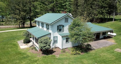 Creek side house with fireplace and concrete driveway.
