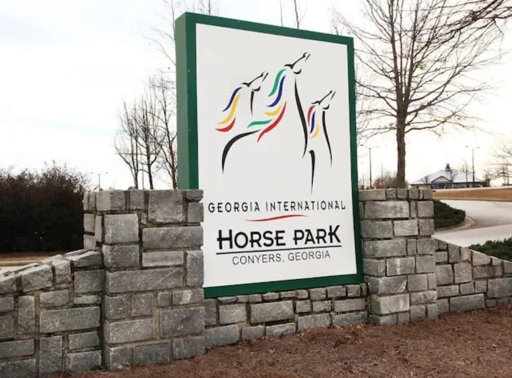 A sign for Georgia International Horse Park in Conyers, Georgia, with a logo of three horses.