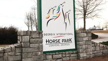 A sign for Georgia International Horse Park in Conyers, Georgia, with a logo of three horses.