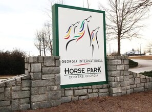 A sign for Georgia International Horse Park in Conyers, Georgia, with a logo of three horses.