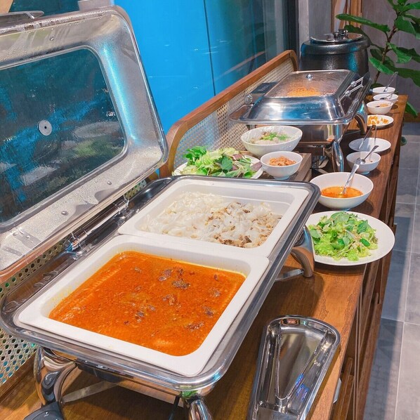 A buffet setup with various dishes including rice, soup, and salads.