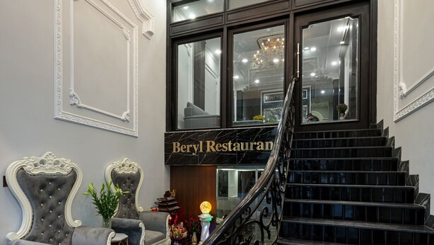 A grand staircase leading to a restaurant entrance with marble flooring and ornate wall decorations. - Beryl Signature Hanoi Hotel (Hanoi)