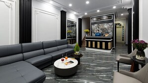 A modern hotel lobby with a black leather sofa, a reception desk, and a marble floor. - Beryl Signature Hanoi Hotel (Hanoi)