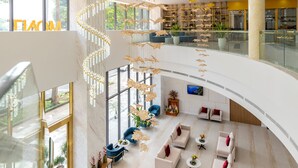 A spacious lobby with a high ceiling, a central spiral staircase, and a seating area with sofas and tables. -  Petro House Vung Tau (Block A) (Ho Chi Minh City)