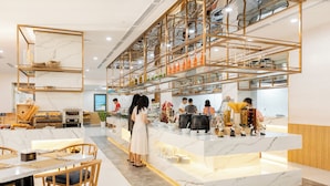 A modern restaurant with marble countertops, wooden chairs, and a central serving area with staff. -  Petro House Vung Tau (Block A) (Ho Chi Minh City)
