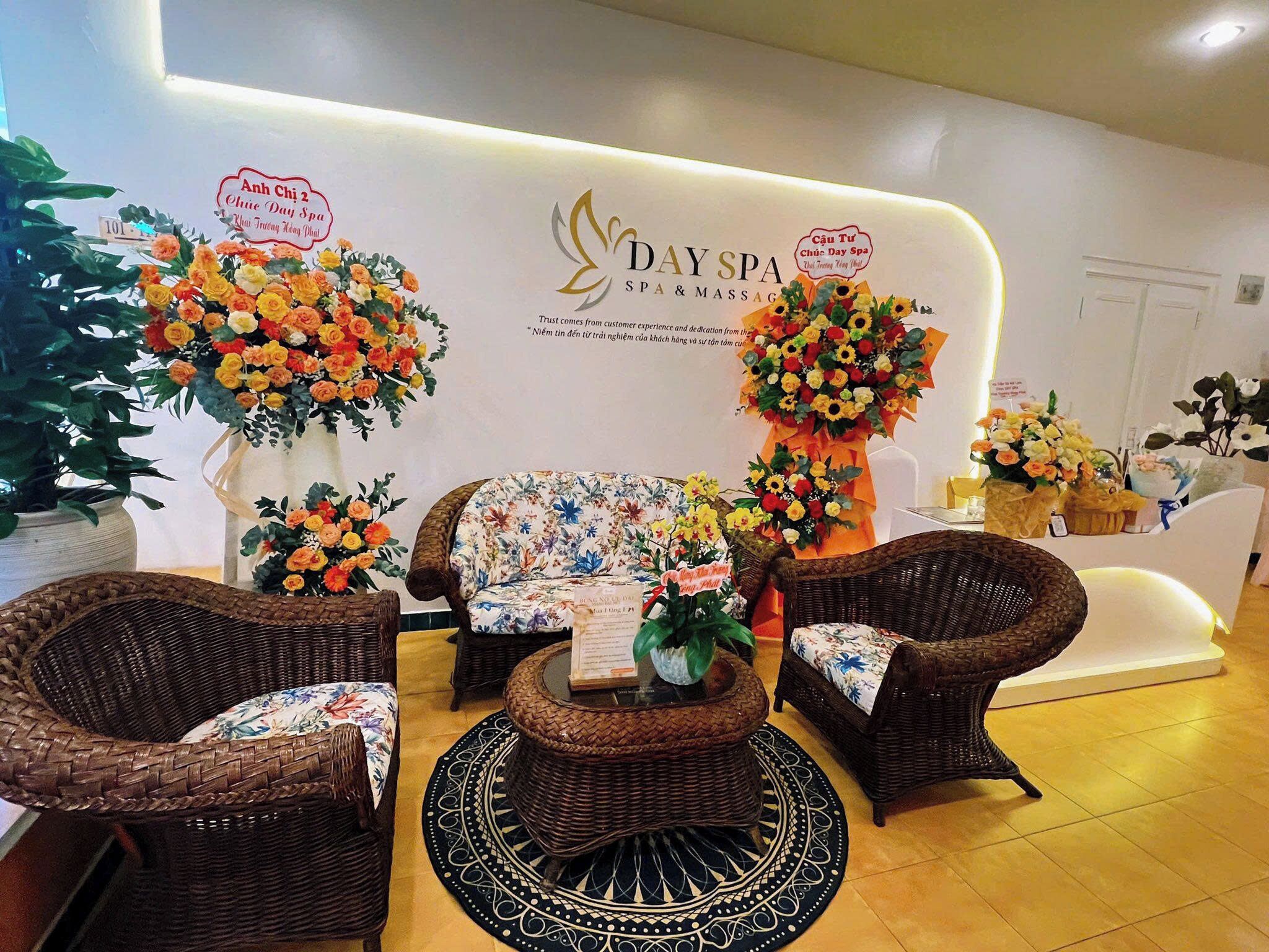 A reception area with wicker furniture, floral arrangements, and a sign for 'DAY SPA SPA & MASSAGE'.
