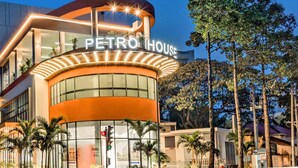 A modern hotel with a curved facade, large windows, and a prominent sign reading "PETRO HOUSE". -  Petro House Vung Tau (Block A) (Ho Chi Minh City)