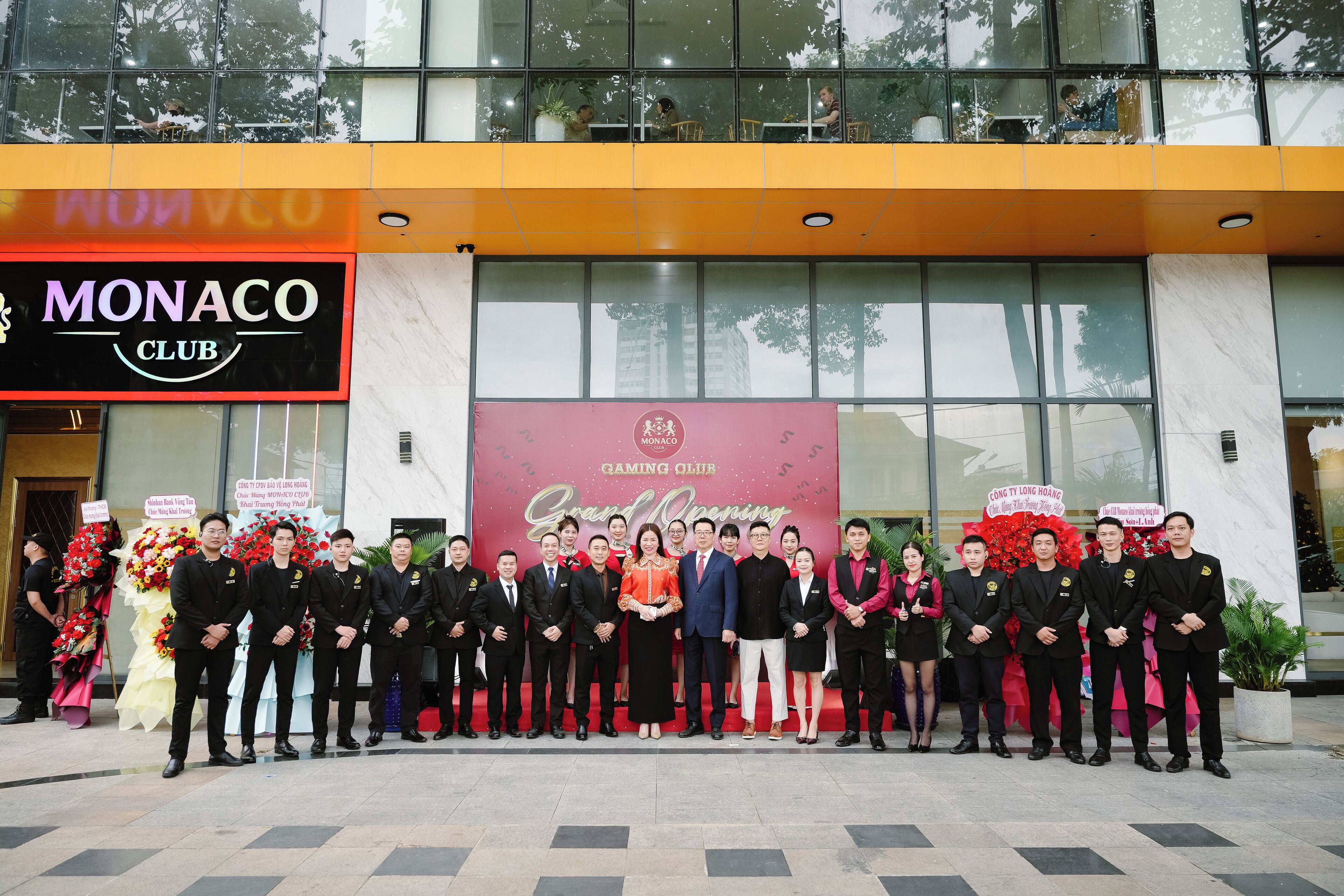 Un grupo de personas de pie frente a un edificio con un letrero que dice "Monaco Club".