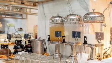 A buffet setup with multiple beverage dispensers and a variety of food containers.