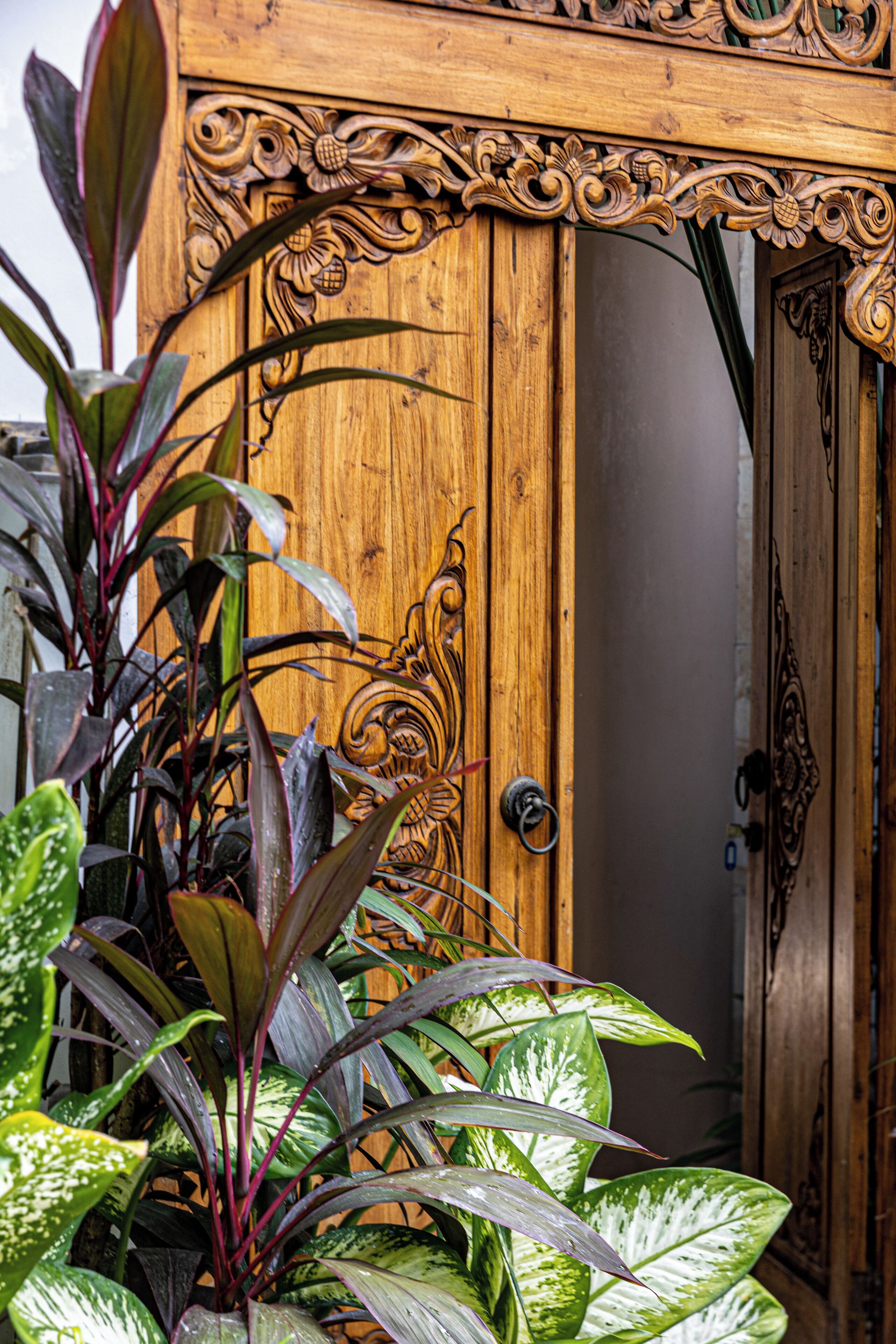 A wooden door with intricate carvings and a metal handle.