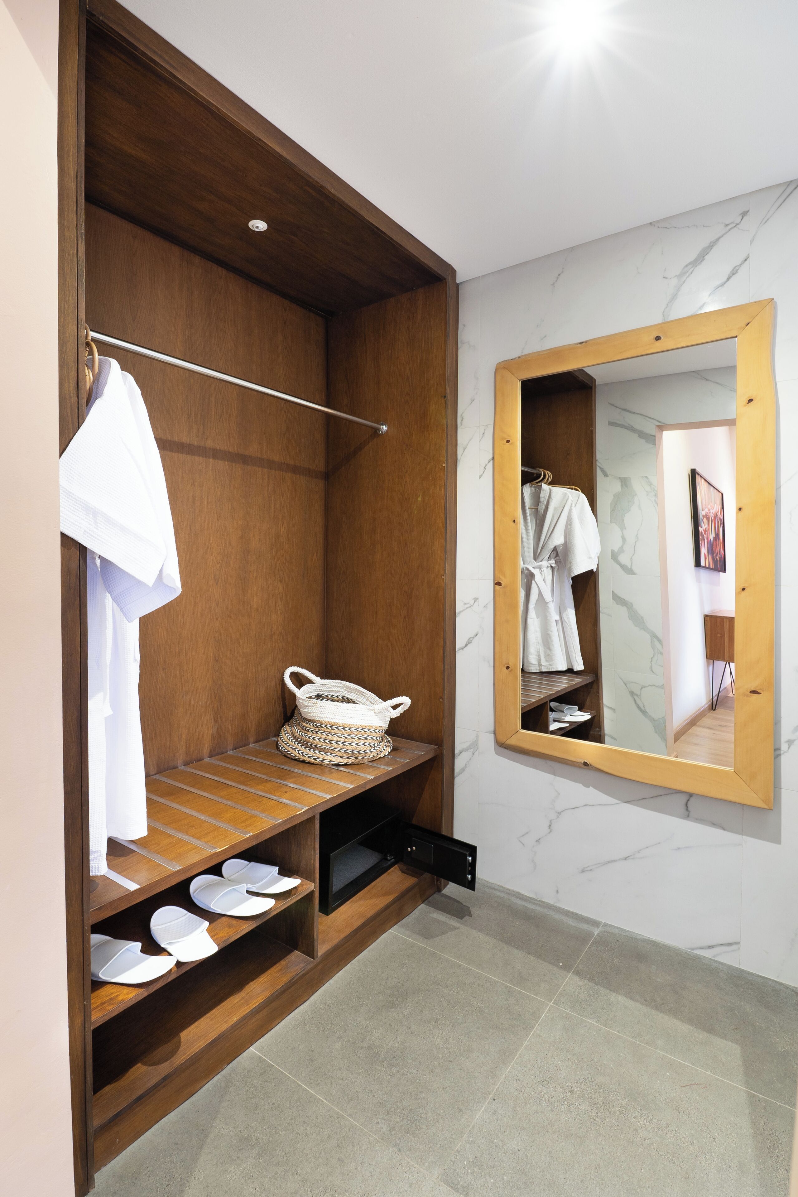 A walk-in closet with wooden shelving, a hanging rack, and a mirror.