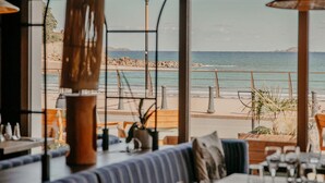A restaurant with outdoor seating overlooking a beach.
