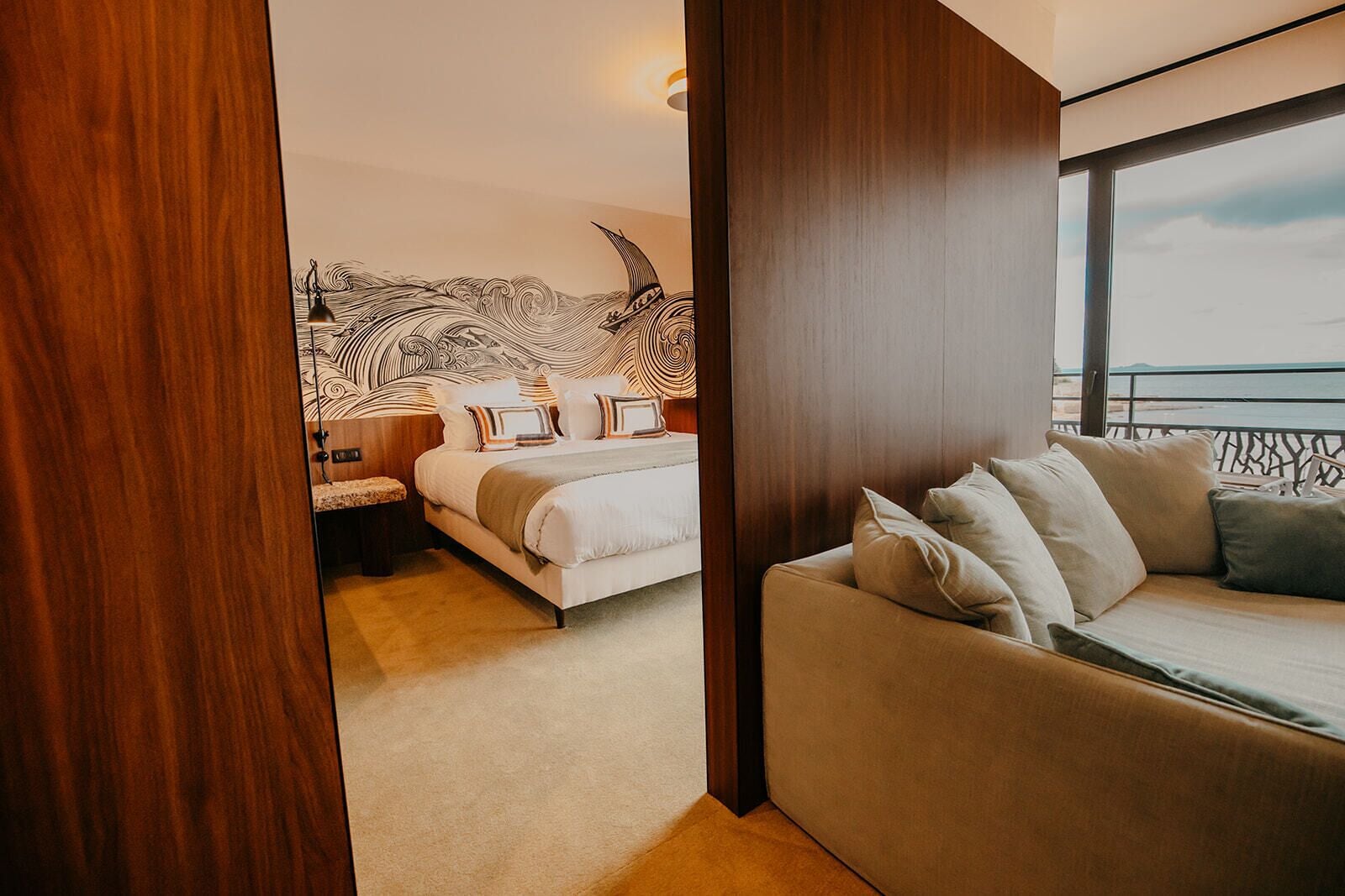 Une chambre d’hôtel moderne avec un grand lit, un canapé et une vue sur la mer.