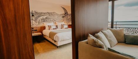 Une chambre d’hôtel moderne avec un grand lit, un canapé et une vue sur la mer.
