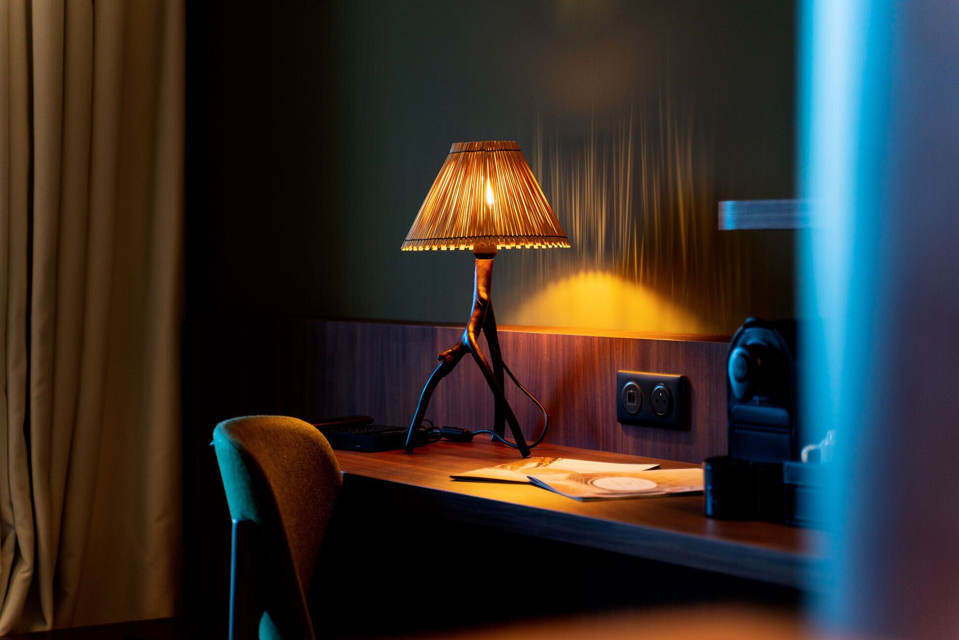 A desk with a lamp, a chair, and a keyboard.