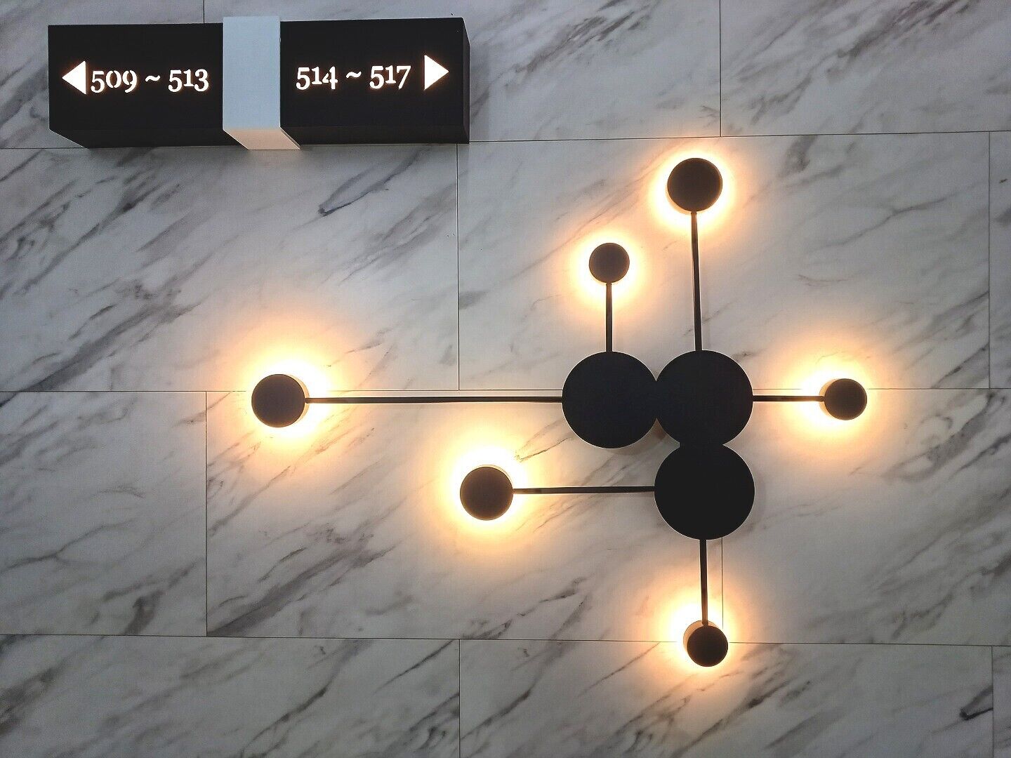 A marble wall with directional signs indicating room numbers 509-513 and 514-517.