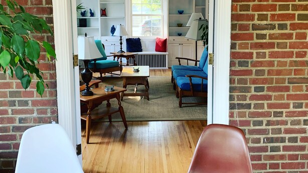 A cozy living room with a brick wall, a white door, and a view of the outside. - Historic Brick Colonial w/Amazing Kitchen- Close to downtown (Omaha)
