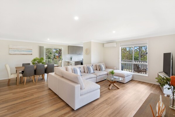 Relax in this spacious living area with a large L-shaped sofa, dining table, and flat-screen TV.