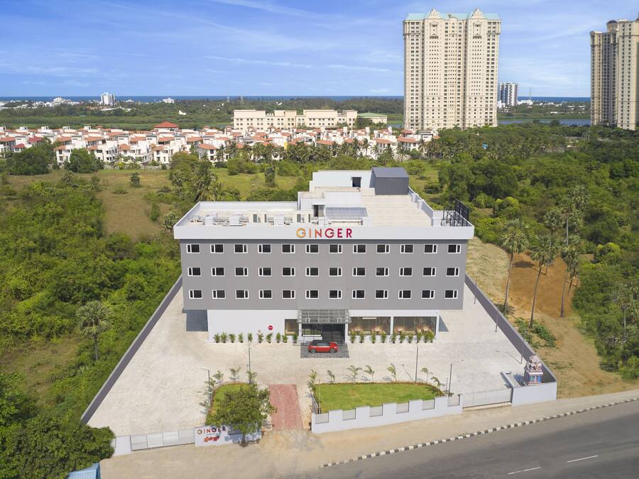 Il s’agit d’un bâtiment moderne doté d’un toit plat et d’une enseigne indiquant le nom « GINGER ». Il comporte plusieurs étages et un espace de stationnement à l’avant.