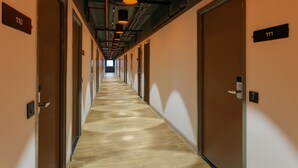 Un largo pasillo estrecho con puertas numeradas 110 y 111.