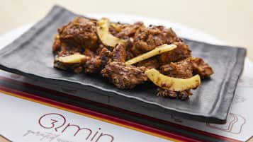 A plate of food on a black plate with a logo that reads "3min gourmet quality cuisine".