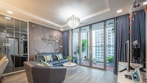 Ein modernes Wohnzimmer mit einer Couch, einem Couchtisch und einem Schreibtisch mit Bügelbrett.