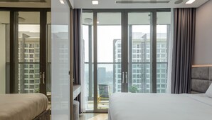 Ein modernes Hotelzimmer mit einem großen Bett, einem Schreibtisch und einem Balkon mit Blick auf die Stadt.