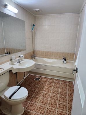 A bathroom with a toilet, sink, and bathtub. - Hotel Hany (Daejeon)