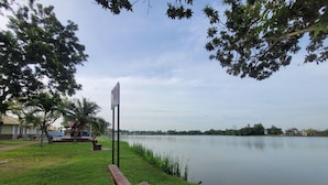 A park bench by a calm lake with a signpost in the background. - PendangLakeResort (Bukit Raya)