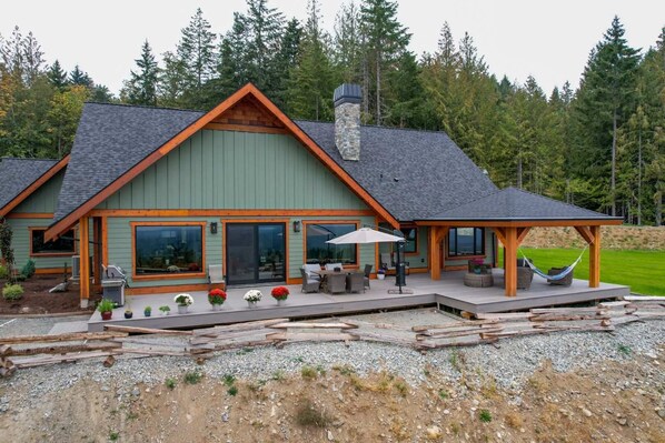 Relax on the spacious deck with outdoor seating and a hammock, taking in views of the surrounding forest.