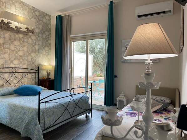 Relax in this stylish bedroom with a large bed, floor lamp, and sliding glass door leading to a scenic view.