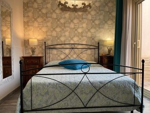 Cozy retreat with a metal-framed bed, patterned bedspread, and decorative ceiling medallion.