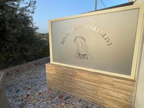 Discover the historic charm of Relais Dei Ulli, set amidst a picturesque Mediterranean landscape with ancient olive trees.