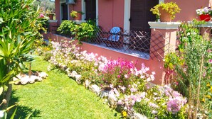 A pink building with a fenced porch, air conditioning units, and potted plants. - Holiday House Skaros in Honigtal, Agios Georgios North, Pagon (Corfu)