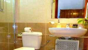 A bathroom with a toilet, shower, sink, and a mirror above the sink. - Holiday House Skaros in Honigtal, Agios Georgios North, Pagon (Corfu)