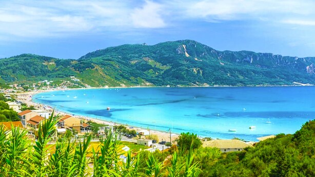 A coastal town with a beach, clear blue waters, and lush green hills in the background. - Holiday House Skaros in Honigtal, Agios Georgios North, Pagon (Corfu)