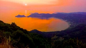 A panoramic view of a coastal landscape with a calm body of water, hills, and a clear sky. - Holiday House Skaros in Honigtal, Agios Georgios North, Pagon (Corfu)