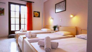 A hotel room with two beds, a window with curtains, a painting on the wall, and a nightstand with a lamp. - Holiday House Skaros in Honigtal, Agios Georgios North, Pagon (Corfu)