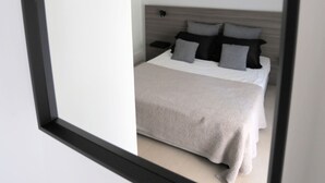 A bedroom with a bed, a nightstand, and a headboard. - Junior Unicorn Suite (Athens)